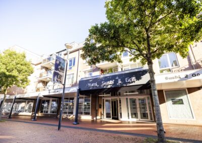 Exterieur en entree van Yumi Sushi & Grill in Brunssum, gevestigd in een modern pand met grote ramen en duidelijke gevelreclame.