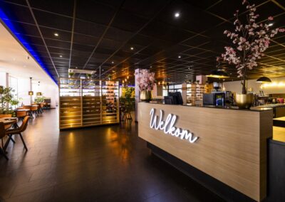 De ontvangstbalie van Yumi Sushi & Grill straalt gastvrijheid en stijl uit, met een verlicht