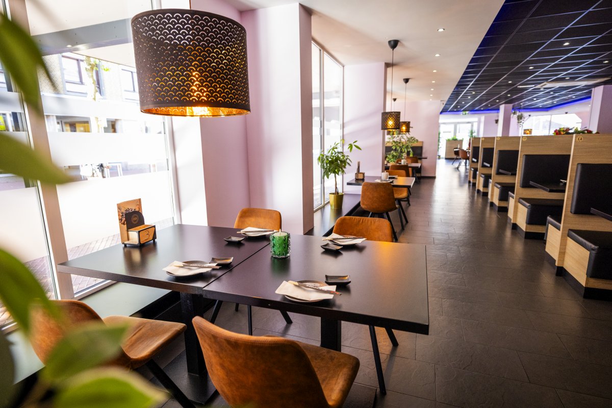 Interieur Het interieur van Yumi Sushi & Grill straalt een eigentijdse en warme sfeer uit. De ruimte biedt zowel comfortabele booth-zitplaatsen met houten panelen en zwarte kussens als losse tafels aan het raam met uitzicht op de omgeving.